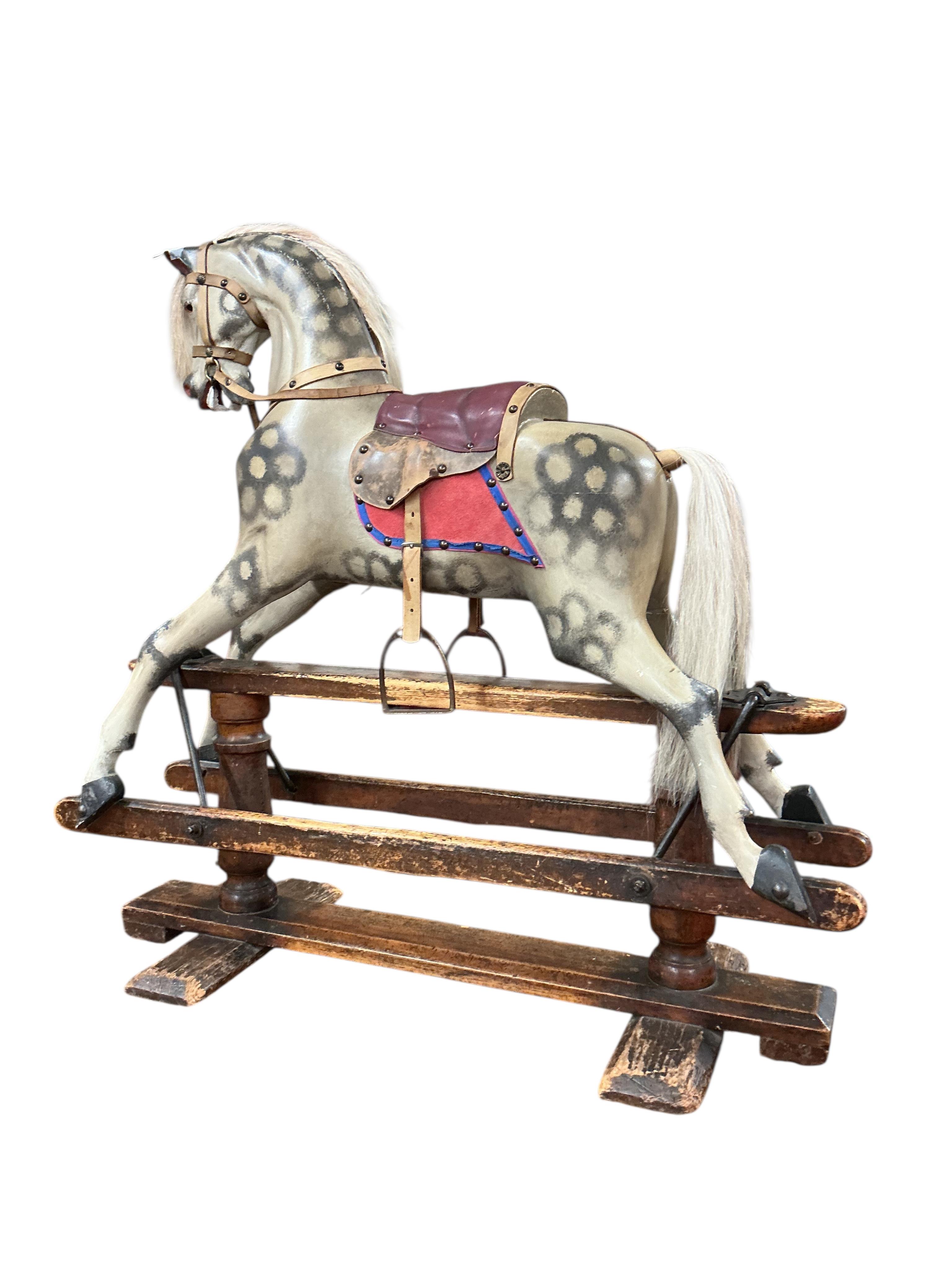 An Ayres type dappled grey painted rocking horse, pine base and runners with good patination and applied brass roundels to both the base and the horse celebrating Queen Victoria‘s Golden Jubilee in 1887, the horse has be